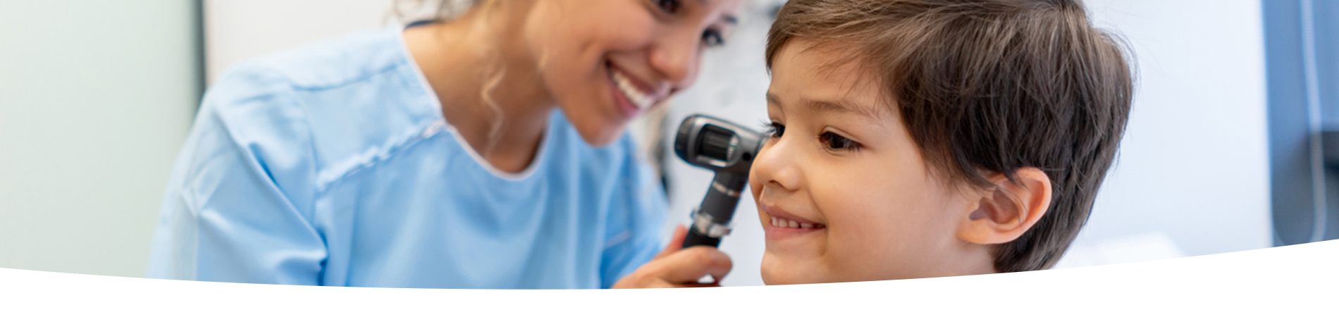 Boy getting his ear checked by a doctor