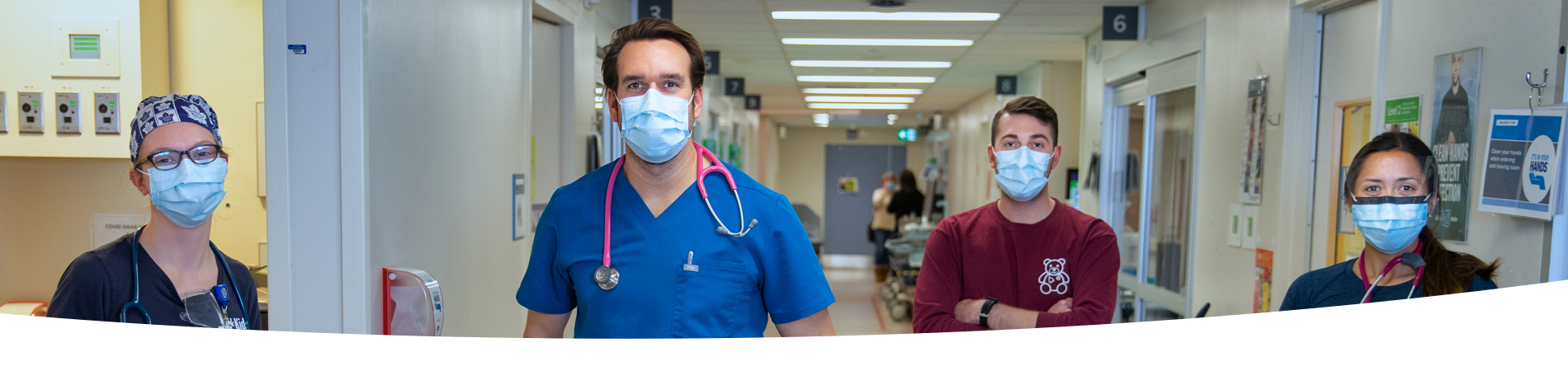 Nurses and staff in masks standing in a hallway of the ED