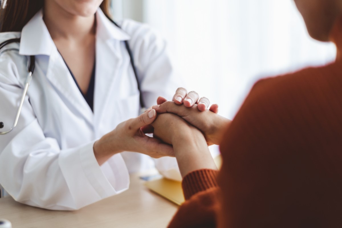 Clinician holding hand of young patient