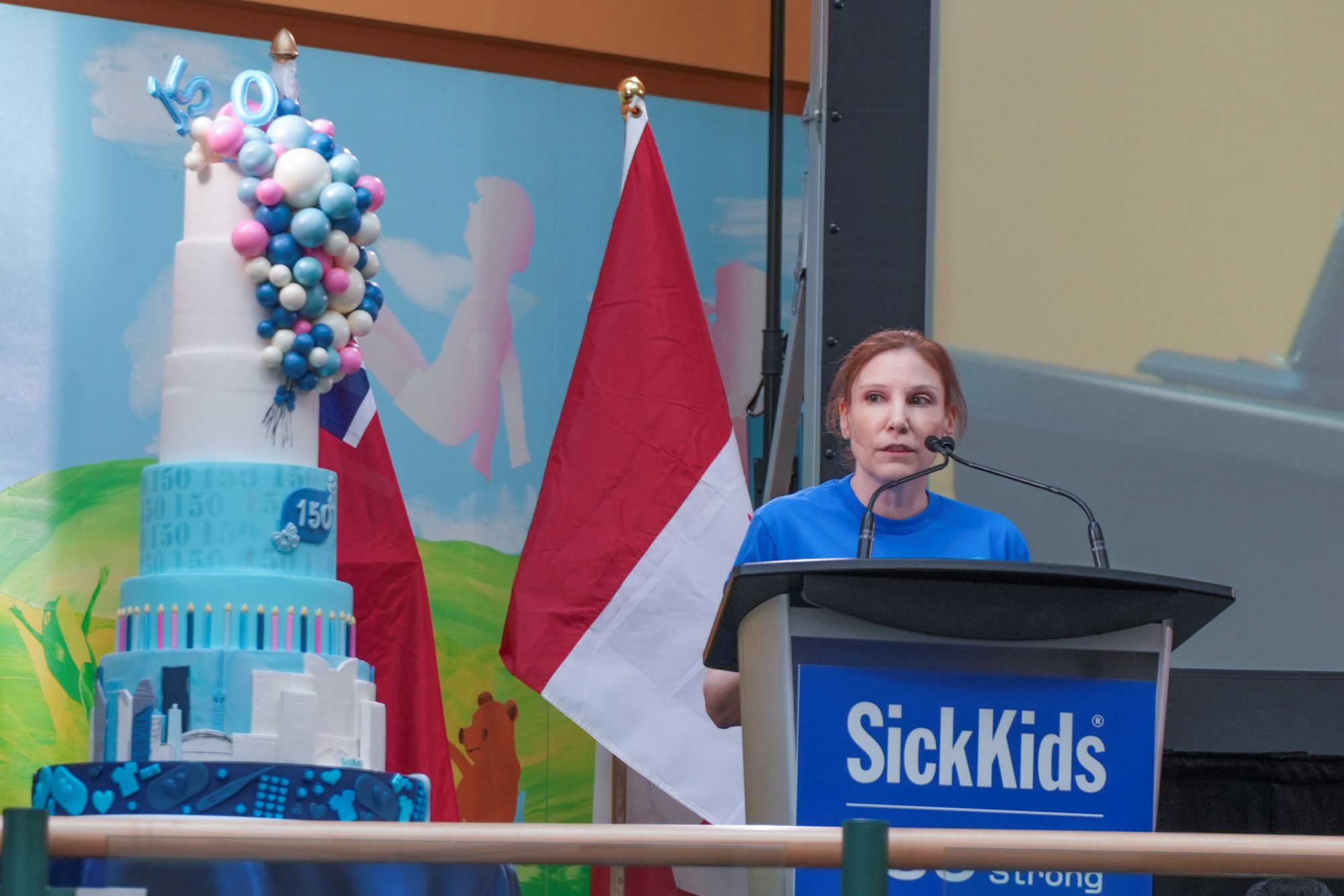 Natalie Wilson speaking at the podium on the Atrium stage